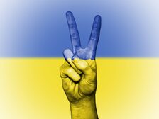 Das Bild zeigt eine Hand vor Ukraine-Flagge