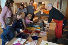 Kleine und große Besucher:innen an der Druckstation des Gutenberg-Museums.