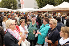 Besucherinnen des Marktfrühstücks unterhalten sich bei einem Glas Wein.