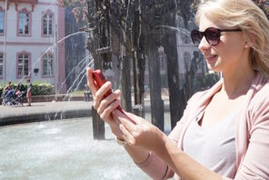 Eine junge Frau ruft auf ihrem Smartphone Infos zum Fastnachtsbrunnen ab © Landeshauptstadt Mainz