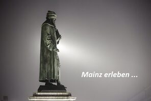 Die Gutenbergstatue am Staatstheater blickt in den herbstlichen Nebel. © mainzplus CITYMARKETING